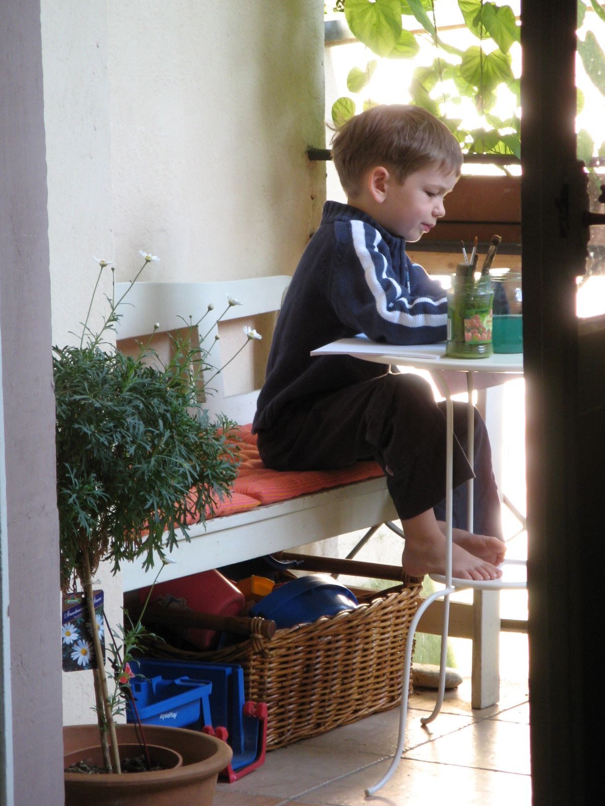 Als Kind beim Malen auf dem Balkon